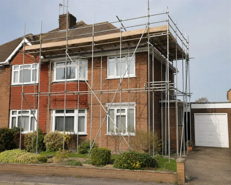 Scaffolding around a house for roof and gutter work