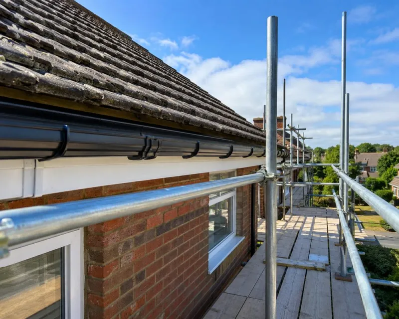 View along a boarded scaffold platform at eaves level